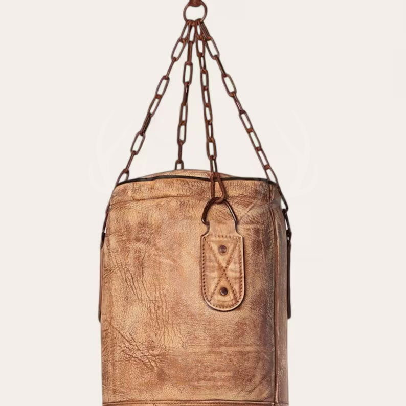 Close-up view of the gravestone- heritage Leather Punching Bag showcasing premium full-grain cowhide leather texture with detailed hand-stitched seams and vintage leather lacing. The image highlights the heavy-duty stainless steel chain and secure fasteners used for hanging, emphasizing durability and professional-grade craftsmanship ideal for boxing, MMA, and fitness training.