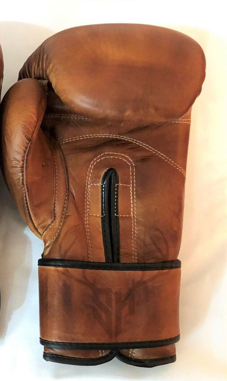 Handcrafted leather boxing gloves with reinforced wrist support and breathable lining for pro fighters.