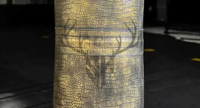 Close-up view of crocodile-embossed cowhide leather texture on Golden Croc Leather Heavy Punching Bag. Showcases rugged, durable design with hand-stitched reinforcement for intensive training.