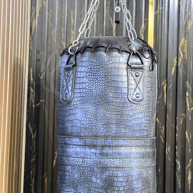 Detailed shot of the premium crocodile-embossed leather texture of the Azure Mauler punching bag, highlighting the deep grain, luxury finish, and handcrafted stitching that sets this bag apart from standard synthetic heavy bags used in boxing and martial arts training.