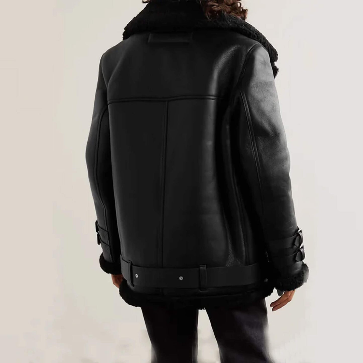 Genuine leather biker shearling jacket in black, designed with a belted hem, asymmetrical front zipper, and double buckle cuffs. This winter shearling coat combines the edge of motorcycle style with the insulation of aviator outerwear. Ideal for men and women, it offers durability, timeless fashion, and reliable warmth, making it a versatile bomber-style shearling jacket for casual, outdoor, and travel wear.