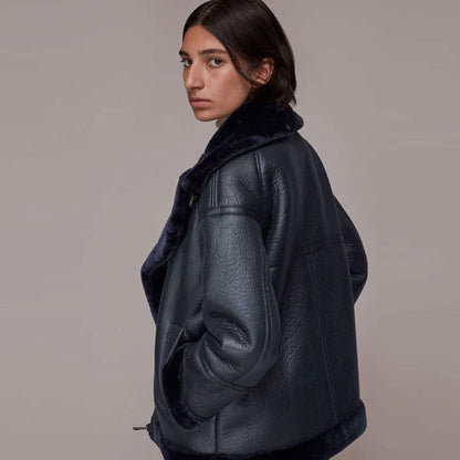 Elegant women’s black shearling leather coat with asymmetrical front zip and shearling-lined interior. Crafted from premium leather, this winter jacket offers both style and warmth with its wide lapel collar and cozy shearling trim. Ideal for women who want a chic outerwear piece for winter outings, casual styling, or fashionable evening wear. A versatile shearling jacket for timeless cold-weather fashion.