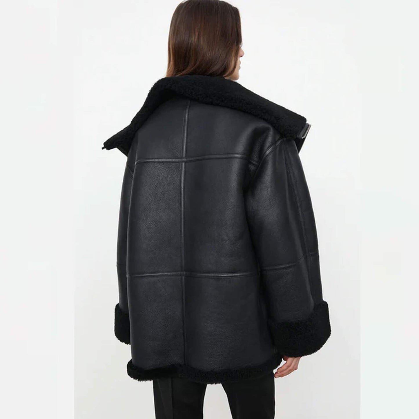 Women’s oversized shearling jacket in goatskin leather with faux fur lining, relaxed fit, wide lapel, folded cuffs, and plush detailing – modern black shearling winter coat designed for fashion and comfort.
