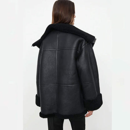 Women’s oversized shearling jacket in goatskin leather with faux fur lining, relaxed fit, wide lapel, folded cuffs, and plush detailing – modern black shearling winter coat designed for fashion and comfort.