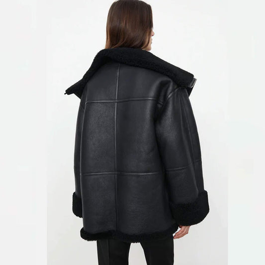 Women’s oversized shearling jacket in goatskin leather with faux fur lining, relaxed fit, wide lapel, folded cuffs, and plush detailing – modern black shearling winter coat designed for fashion and comfort.