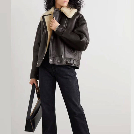 Aurora black shearling leather biker jacket for women featuring premium cowhide leather exterior and cream shearling lining, cropped aviator style with belted waist, front zipper closure, and wide shearling collar. Perfect winter coat for stylish cold-weather fashion, combining durability, warmth, and chic streetwear appeal.