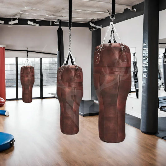 A full view of the Ironclad Titan Uppercut Boxing Bag hanging in a gym, showcasing its inclined uppercut design, premium cowhide leather, reinforced stitching, and heavy-duty steel chains. Perfect for enhancing uppercut techniques and improving boxing and MMA training sessions with realistic resistance.


