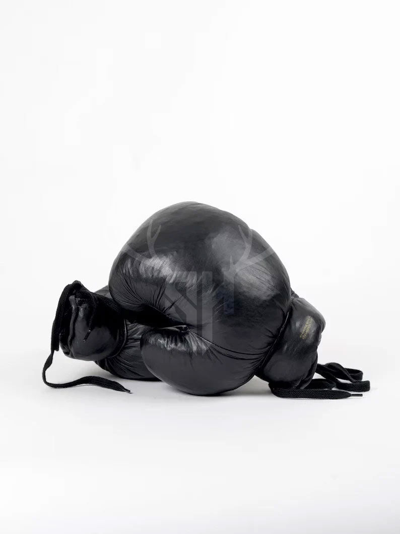 Zoomed-in image of cowhide grain and hand-aged black patina finish on leather boxing gloves. Highlights durable craftsmanship and stylish, rugged vintage appearance.

