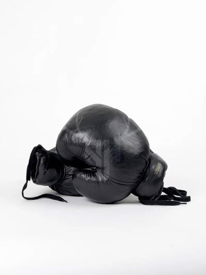 Zoomed-in image of cowhide grain and hand-aged black patina finish on leather boxing gloves. Highlights durable craftsmanship and stylish, rugged vintage appearance.

