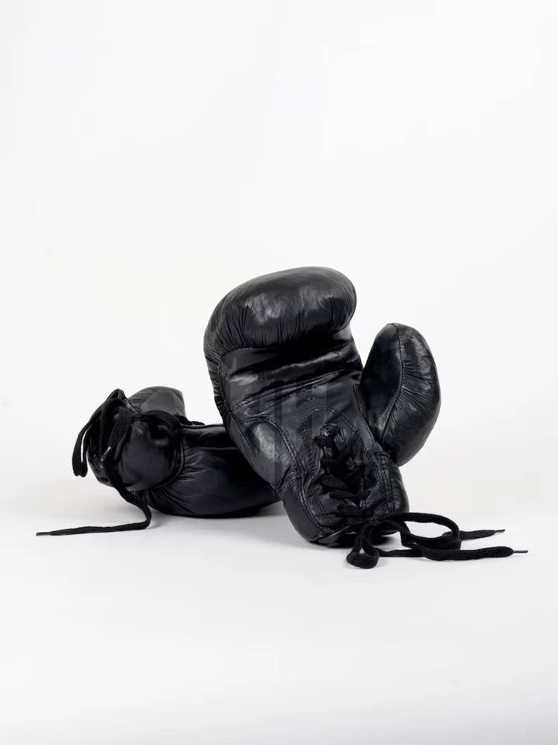 Close-up of Black Vintaro lace-up boxing gloves showing full-grain cowhide leather texture, hand-polished patina finish, and detailed stitching on the wrist support. Ideal for pro fighters and vintage glove collectors.


