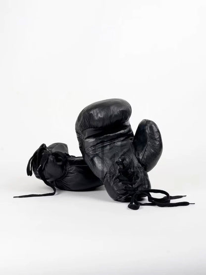 Close-up of Black Vintaro lace-up boxing gloves showing full-grain cowhide leather texture, hand-polished patina finish, and detailed stitching on the wrist support. Ideal for pro fighters and vintage glove collectors.

