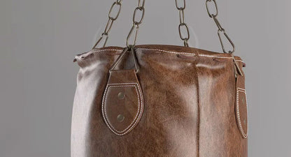 Close-up of premium natural cowhide leather texture on Burnt Brown Leather Heavy Punching Bag. Showcases the durable, vintage style, natural grain, and reinforced stitching. Perfect for heavy-duty boxing, MMA, Muay Thai, and fitness workouts. High-quality craftsmanship ensures long-lasting punching bag performance.