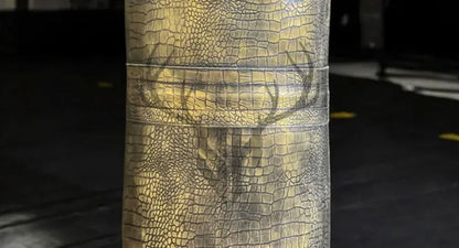 Close-up view of crocodile-embossed cowhide leather texture on Golden Croc Leather Heavy Punching Bag. Showcases rugged, durable design with hand-stitched reinforcement for intensive training.