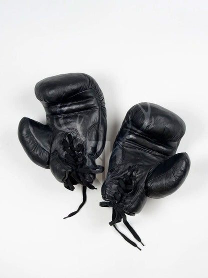 Vintage black leather boxing gloves with classic lace-up design displayed on a white background. Ideal for ecommerce and promotional display for fighters and collectors.

